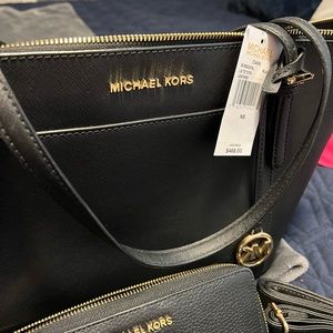 Brand new Michael Kors purse with matching wallet in black.